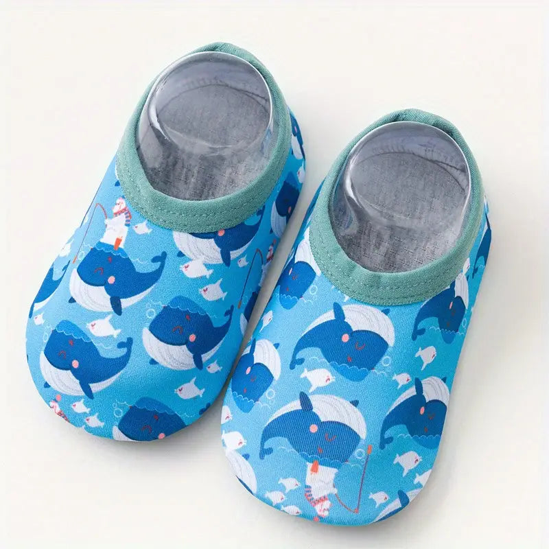 Pair of blue baby shoes with whale pattern on a white background