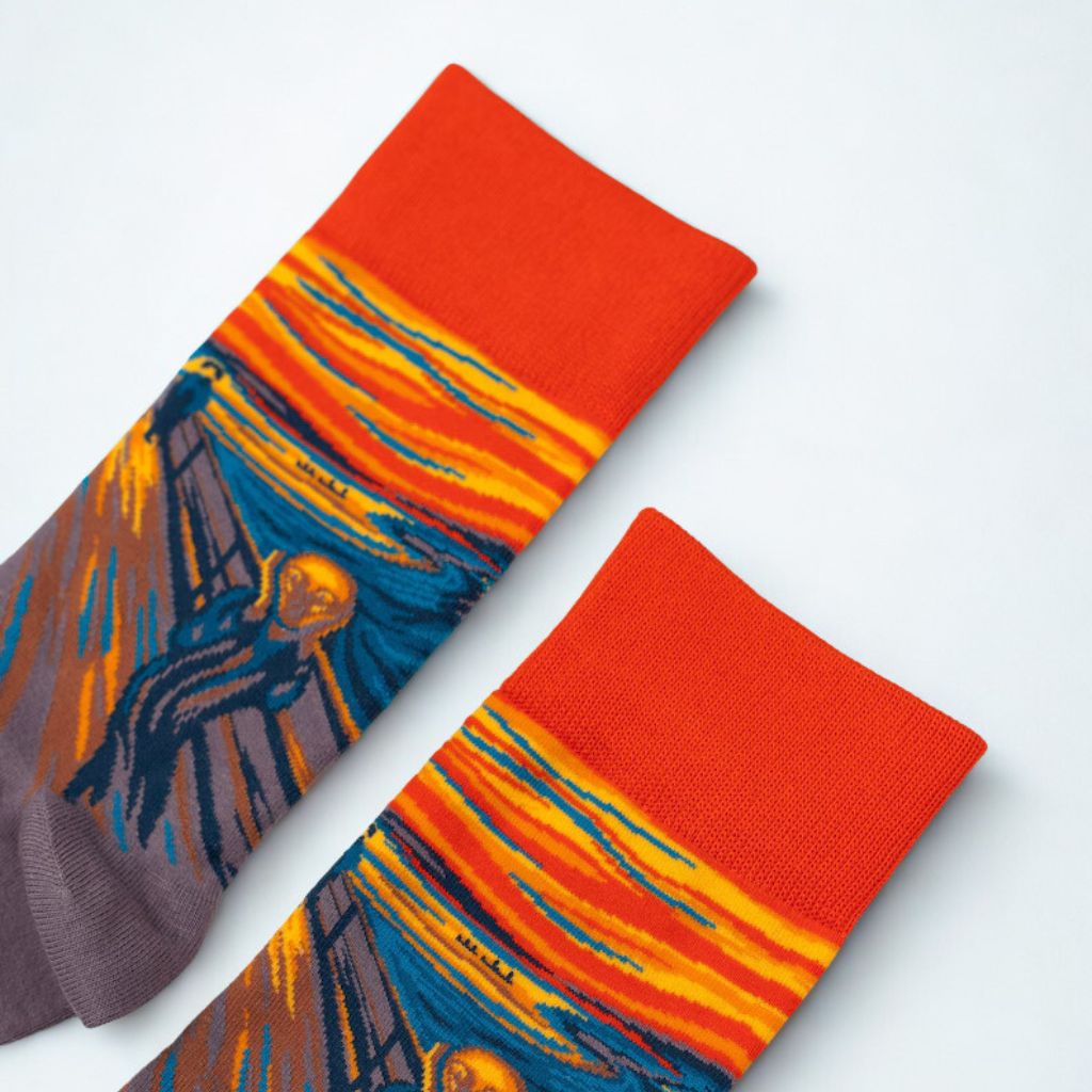 Pair of The Scream art socks arranged diagonally with orange cuffs and detailed knitted artwork