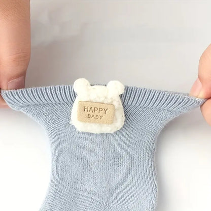 Light blue Cloudy Cuddles baby sock stretched by hand to demonstrate its flexible fit