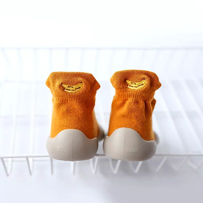 Mustard Mini Walker sock shoes with embroidered banana designs and flexible grey soles