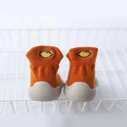 Orange Mini Walker sock shoes with embroidered lemon designs and flexible grey soles
