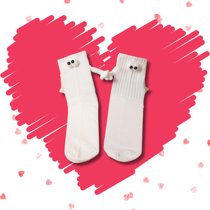 Pair of white Soulmates crew socks holding hands on a pink heart background