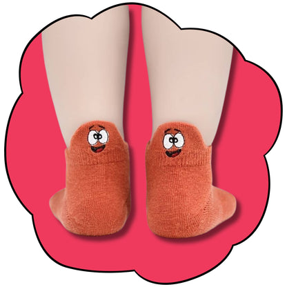 Orange kids ankle socks worn on both feet with embroidered smiling character faces