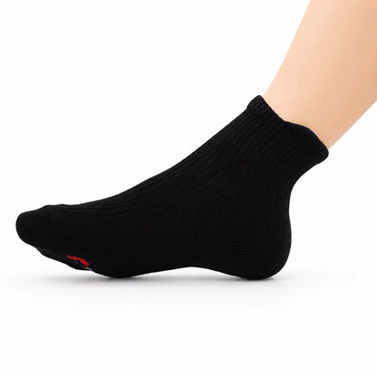 Black ankle compression sock worn with the foot raised to show its flexible fit