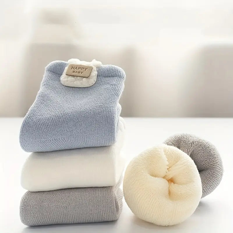Stacked and rolled Cloudy Cuddles baby socks showing their thick plush interiors