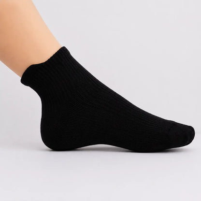 Black ankle compression sock worn from the side against a white studio background