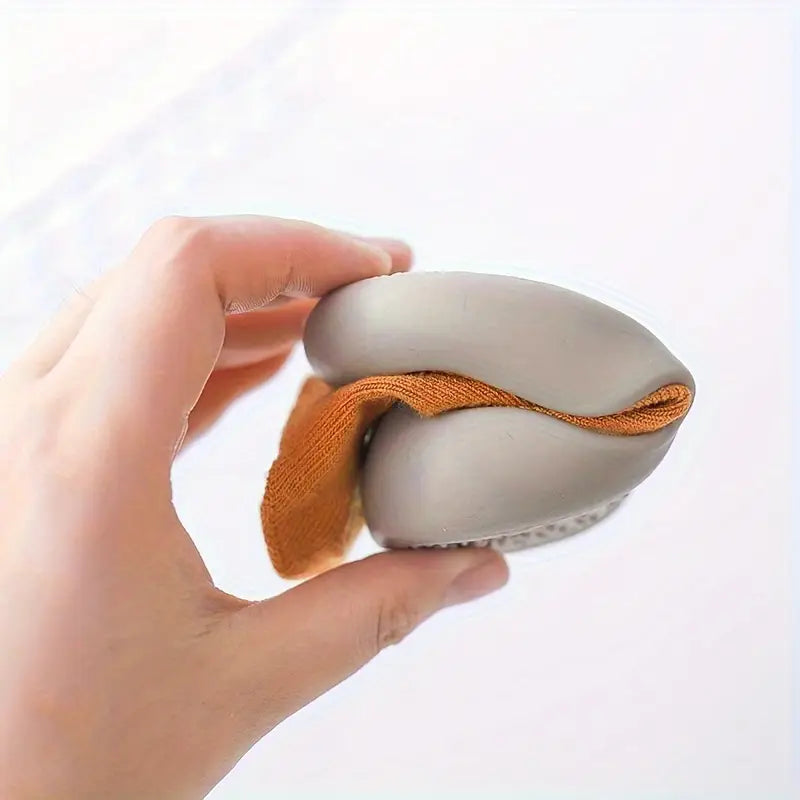 Mini Walker sock shoe folded by hand to demonstrate its flexible soft sole