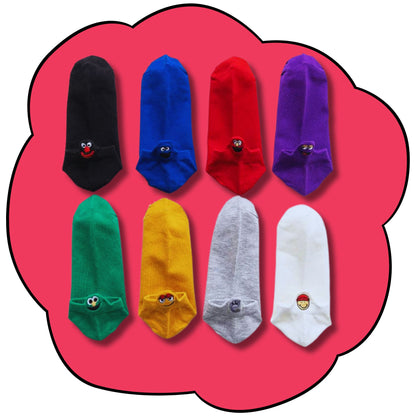 Eight colourful ankle socks arranged in two rows with embroidered character faces at the heel