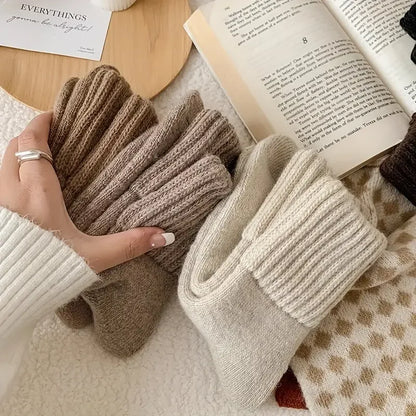Close-up of beige and cream cashmere wool socks showing their thick ribbed cuffs and soft knit