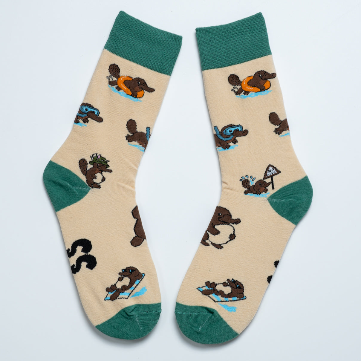Pair of cream platypus crew socks with green cuffs, heels and toes arranged heel to heel