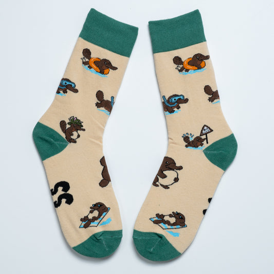 Pair of cream platypus crew socks with green cuffs, heels and toes arranged heel to heel