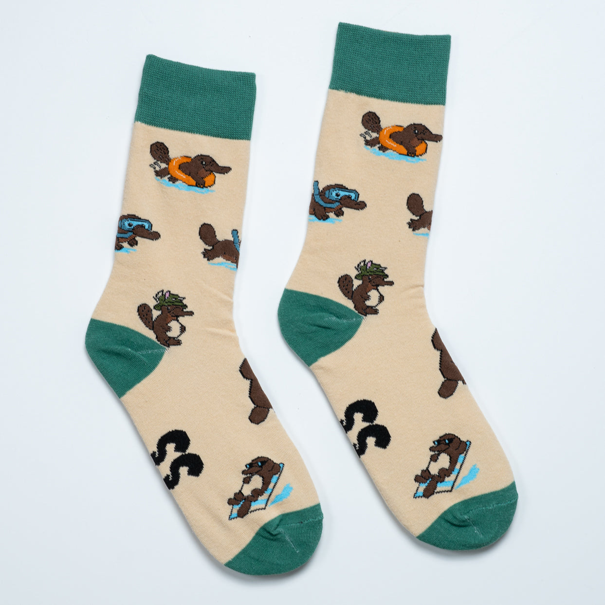Cream platypus socks laid side by side with swimming, snorkelling and lounging platypus designs
