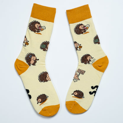 Pair of cream echidna socks laid side by side with playful Australian wildlife illustrations