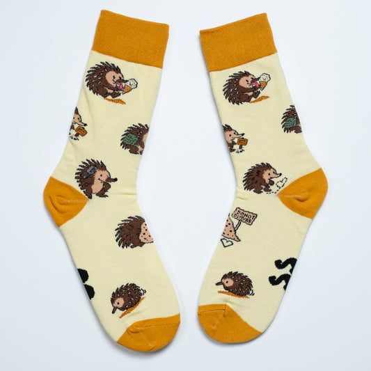 Pair of cream echidna socks laid side by side with playful Australian wildlife illustrations