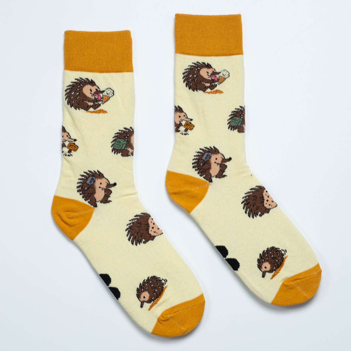 Pair of cream echidna crew socks with mustard cuffs, heels and toes arranged heel to heel
