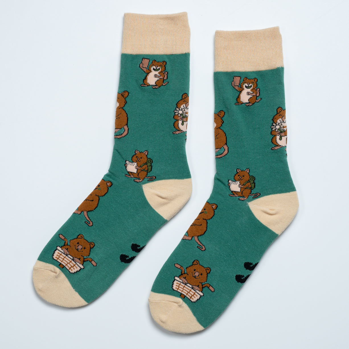 Pair of green Quokka socks laid side by side with selfie, travel and picnic illustrations