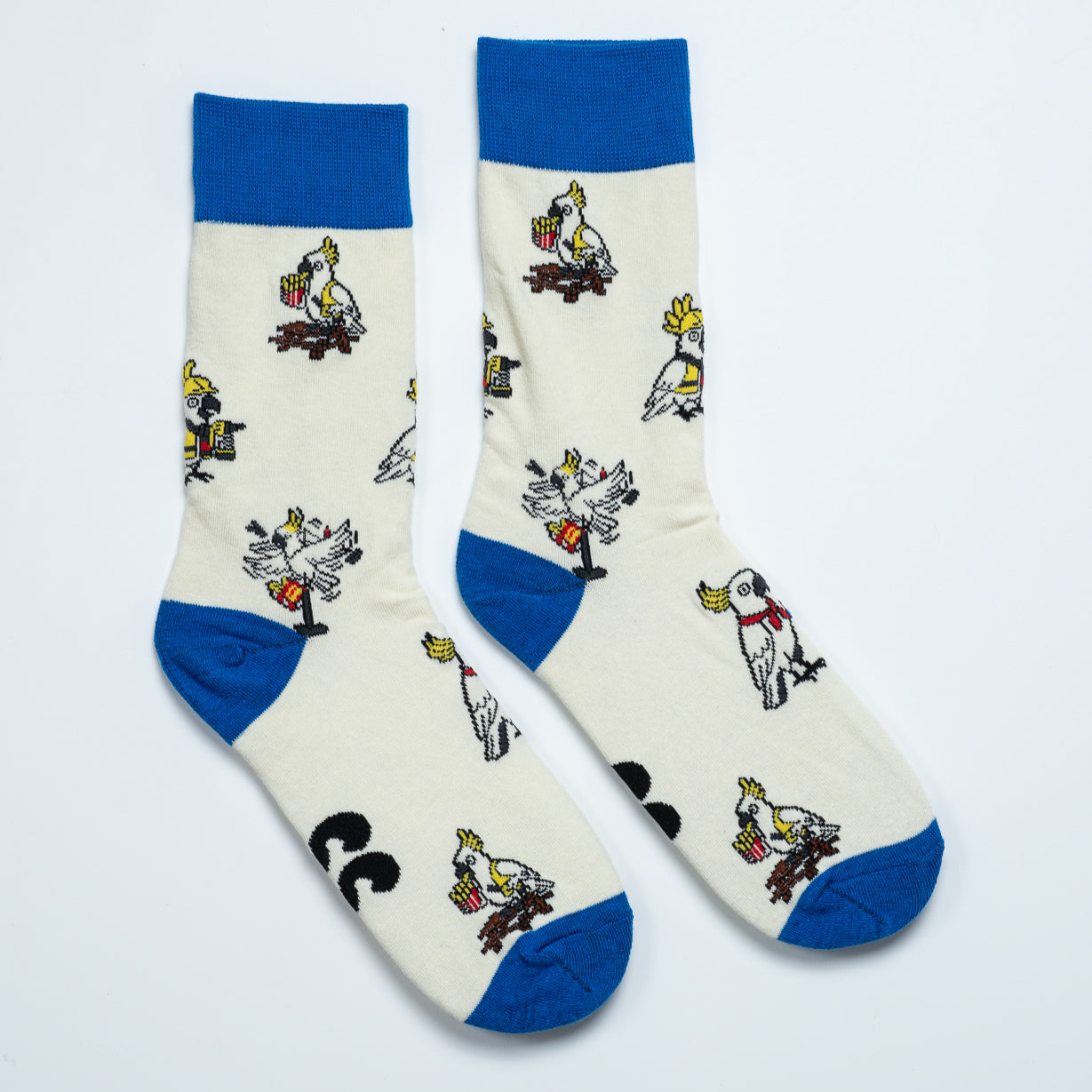 Cream cockatoo crew socks with blue cuffs, heels and toes featuring playful cockatoo illustrations