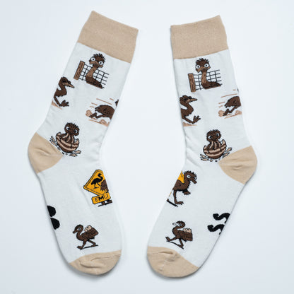 Pair of white emu socks laid side by side with playful emu scenes and an Australian road sign