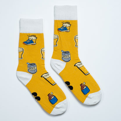 Pair of yellow Beer Sox with beer glasses, cans and sneaker illustrations on a white background