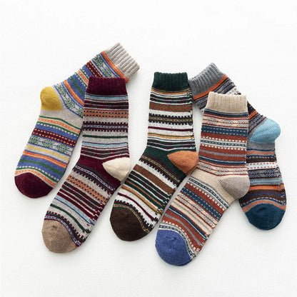 Five colourful winter wool socks arranged upright to show their different patterns and cuffs