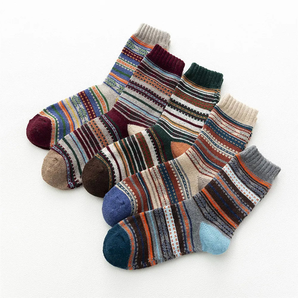 Five patterned wool blend socks overlapping in a fan arrangement on a white background