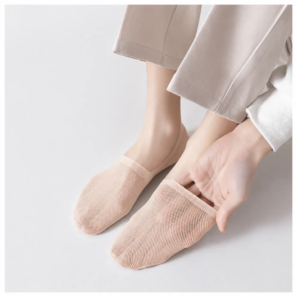 Nude invisible sock pulled at the heel to demonstrate its stretch and secure fit