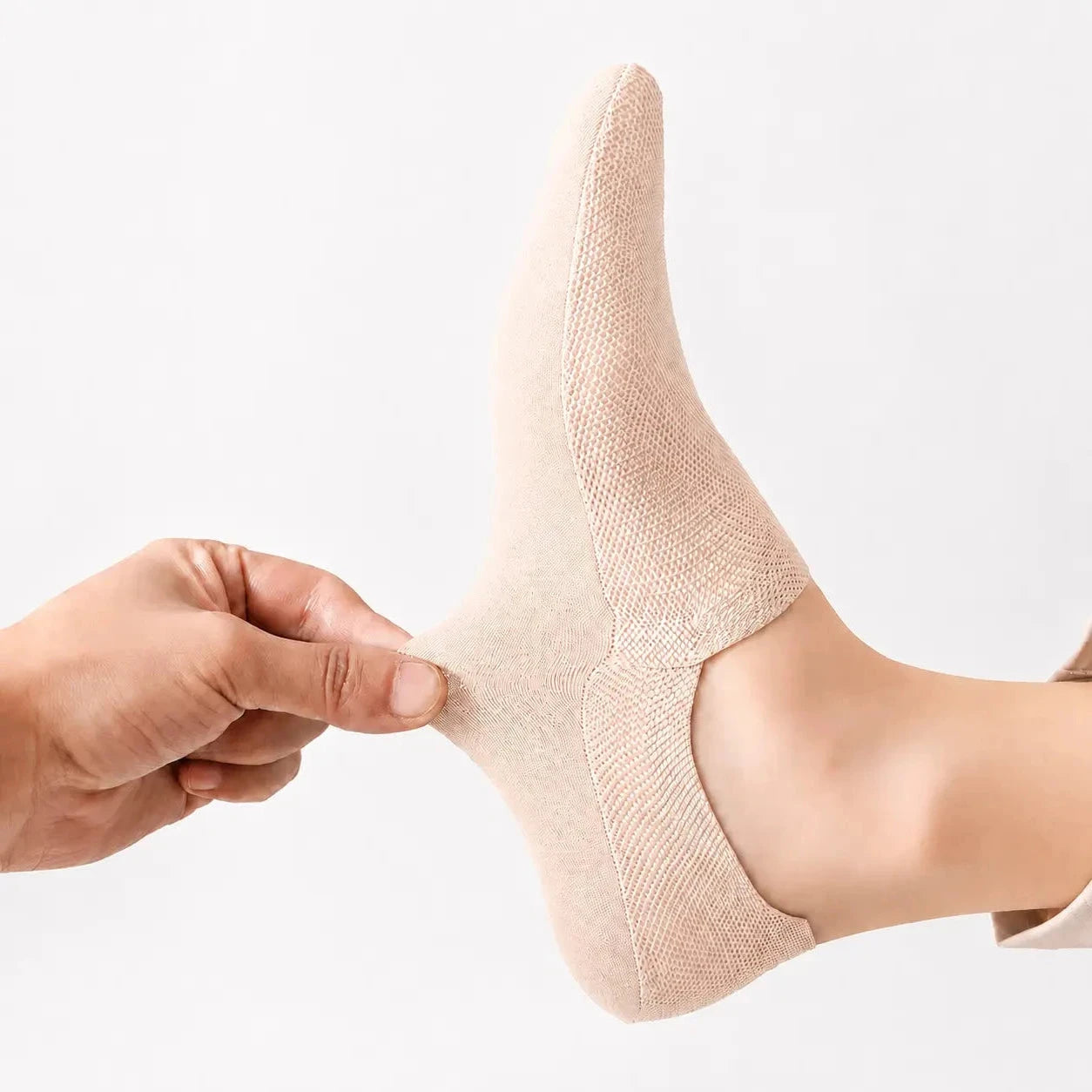 Nude invisible sock pulled at the heel to demonstrate its stretch and secure fit