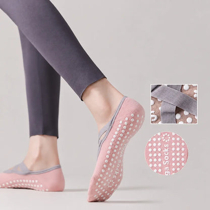 Pink Pilates grip socks worn to show the white non-slip sole and grey crossover straps