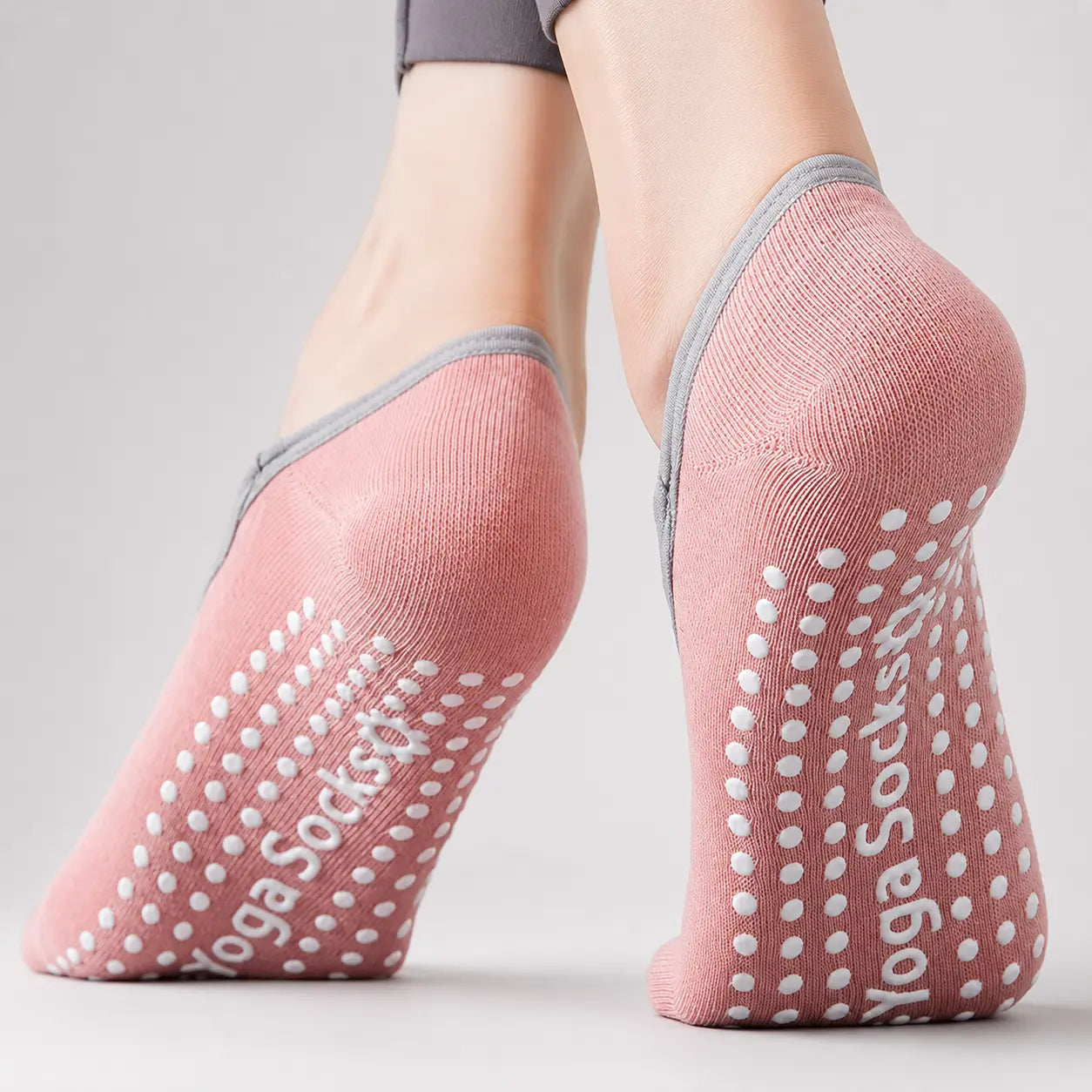Close-up of pink Pilates grip socks showing the heel coverage and non-slip soles