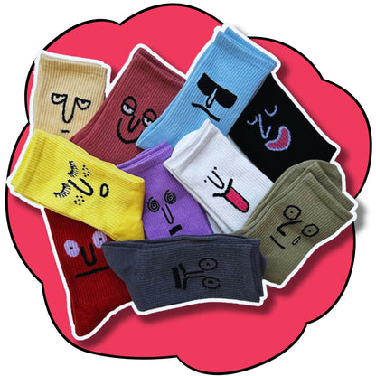Ten folded mood face crew socks arranged across a pink flower background