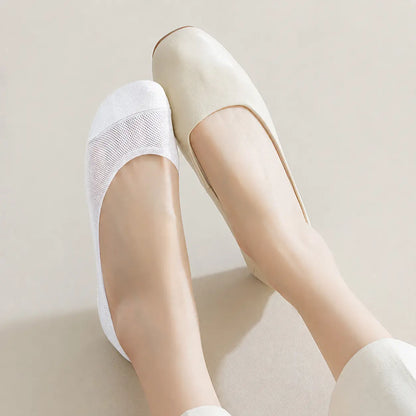 White BareLite footie sock worn with a low-cut cream flat shoe