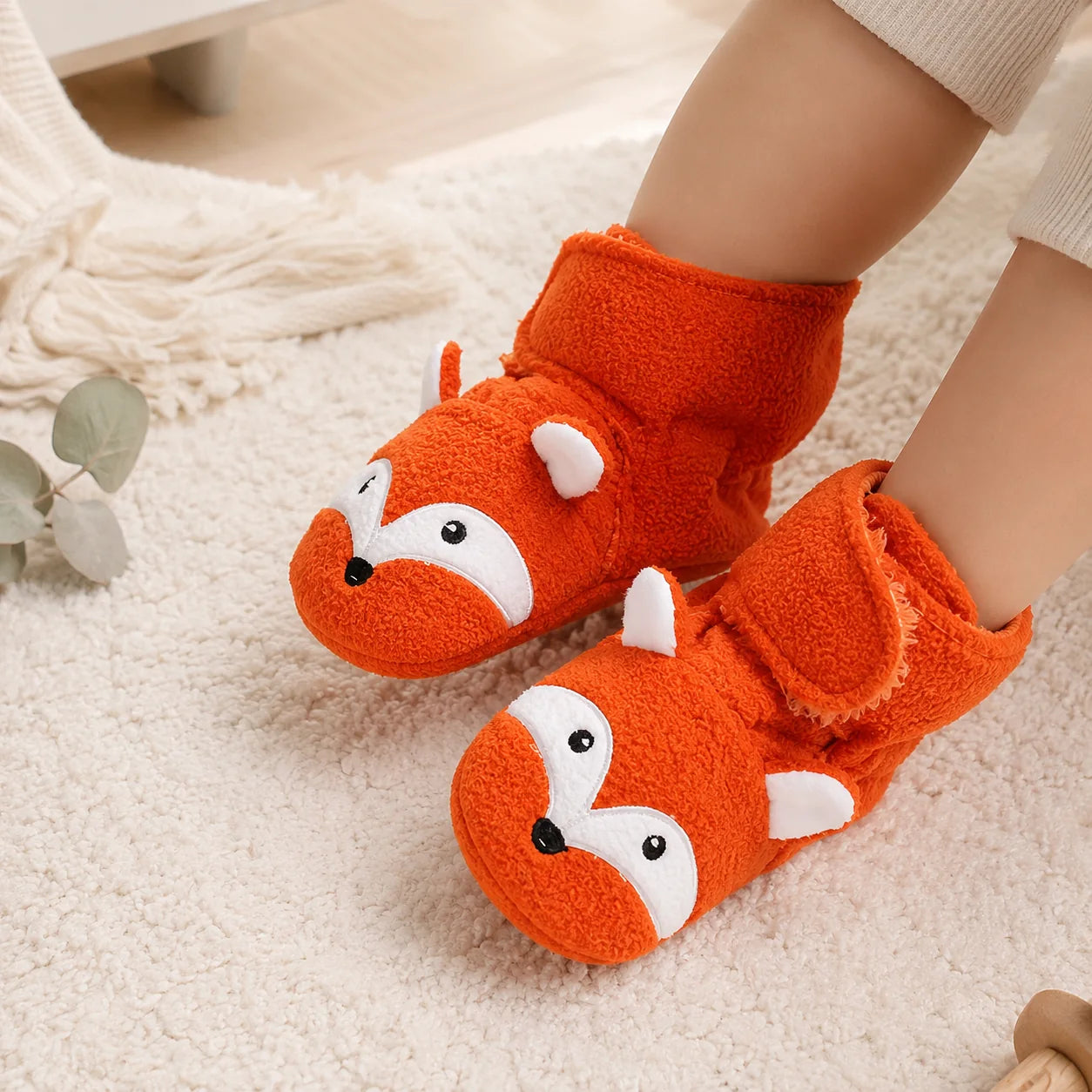 Baby wearing orange fox bootie socks with soft plush fabric and stay-on ankle straps