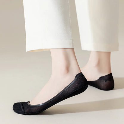 Black BareLite footie socks worn with cream trousers to show their ultra low-cut fit