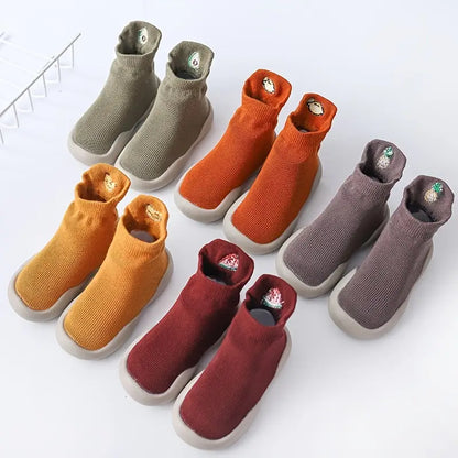 Five pairs of colourful Mini Walker sock shoes arranged on a white studio background