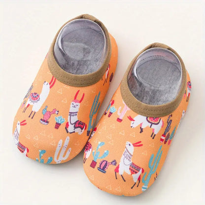 Pair of orange slippers with llama and cactus pattern on a white background