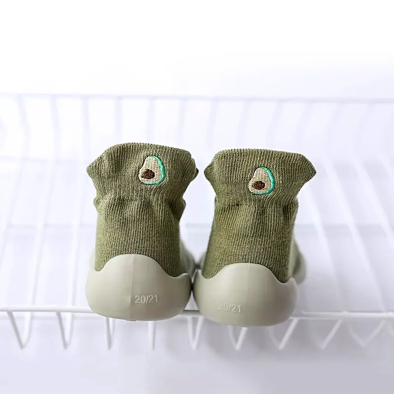 Olive green Mini Walker sock shoes with embroidered avocado designs and flexible grey soles