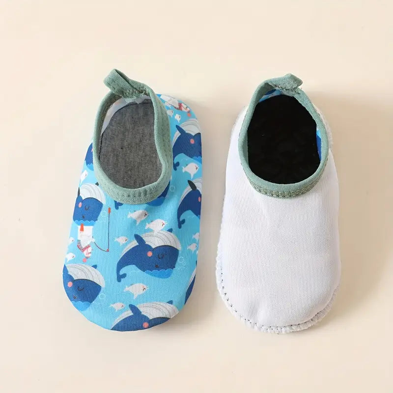 Pair of baby shoes with whale pattern on a beige background
