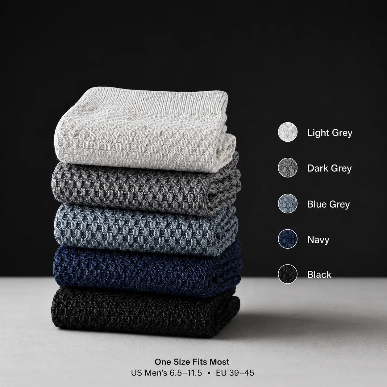 Five folded men’s bamboo crew socks in light grey, dark grey, blue grey, navy and black