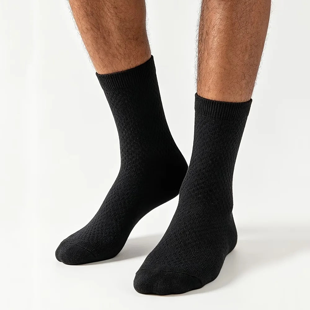 Black men’s bamboo crew socks worn on both feet against a white studio background