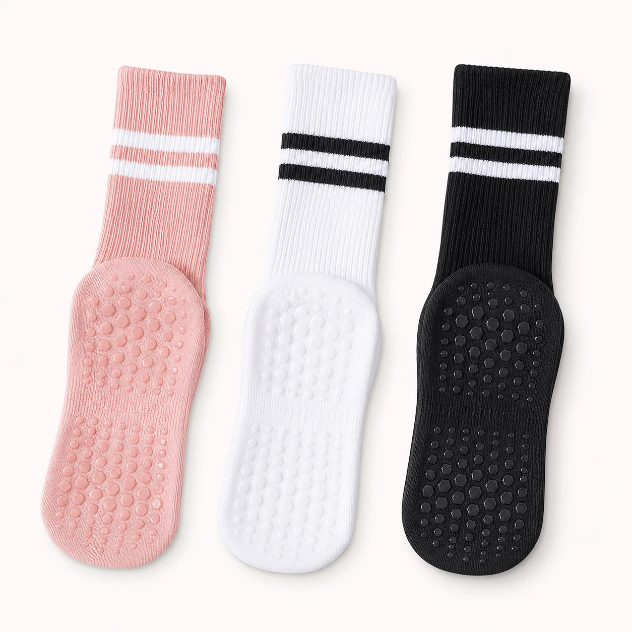 Pink, white and black Studio Crew Grip Socks laid flat to show their full non-slip soles