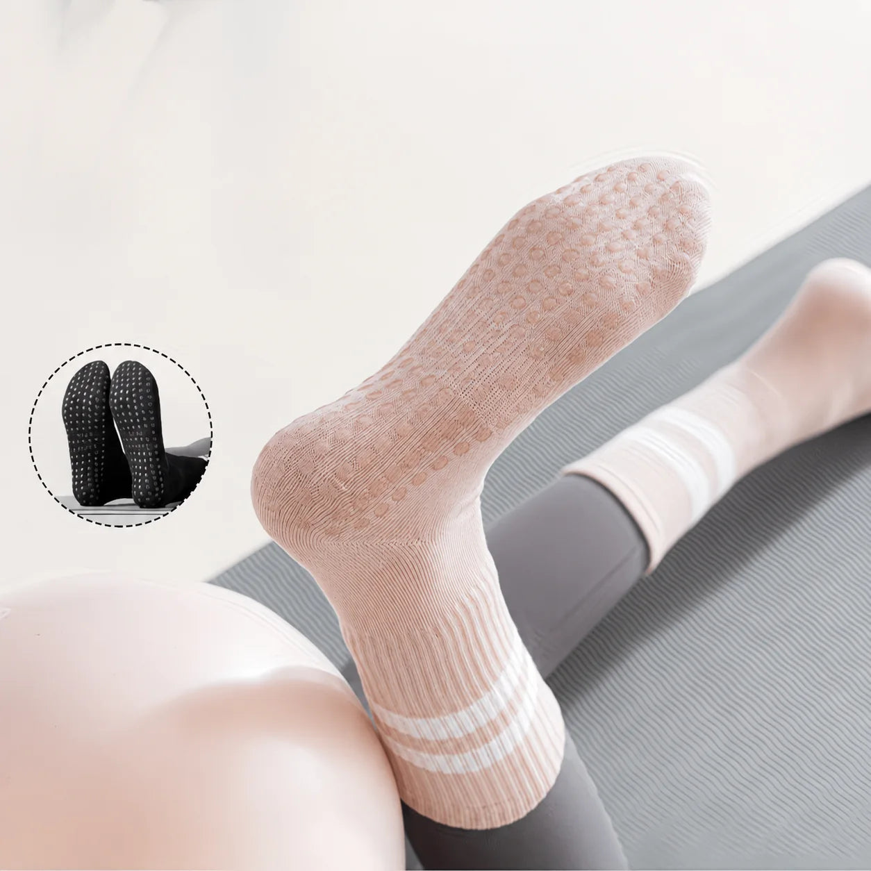 Pink grip sock shown from the sole with white and black Studio Crew Grip Socks in the background