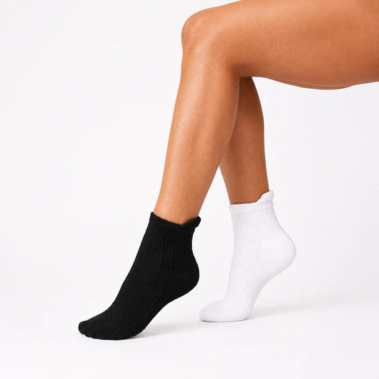 Smiley Sox Ankle Compression Socks in black and white worn on crossed legs