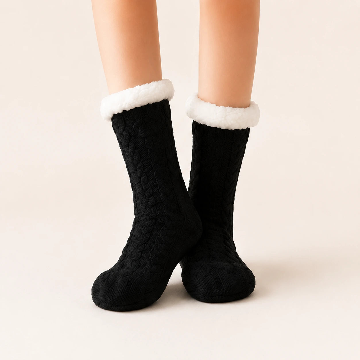 Black sherpa-lined slipper socks worn on feet