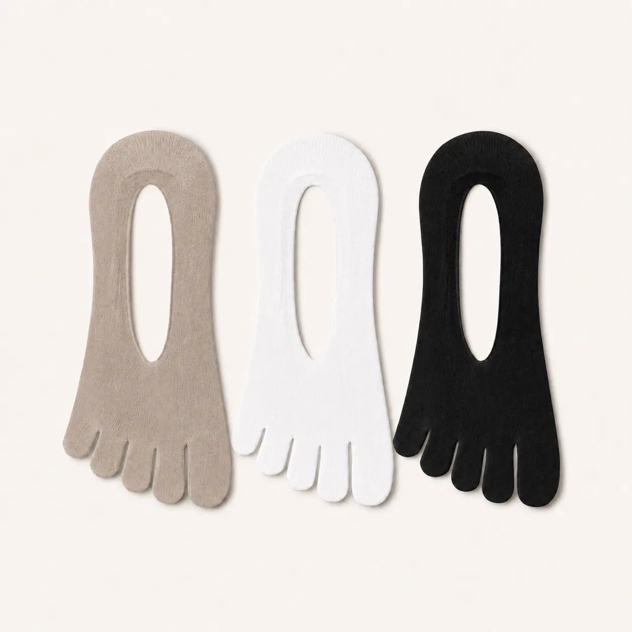 Three pairs of sand beige, black and white BareToe five-toe invisible sock laid flat on a light background